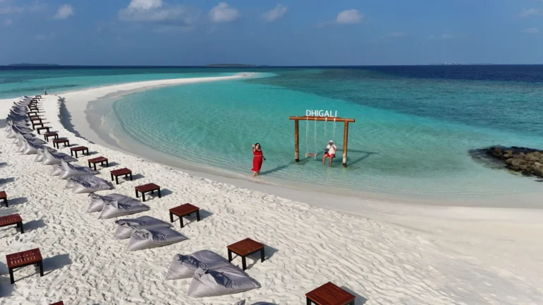Couple on the sandbank at Niva Dhigali Maldives surrounded by turquoise lagoon