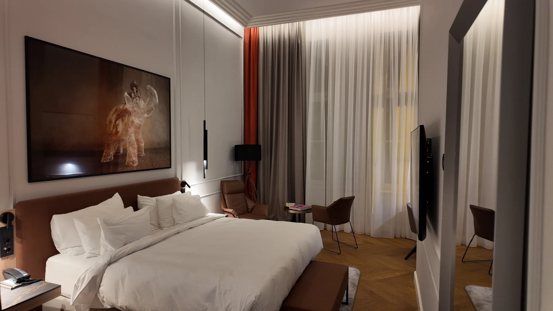 Wide-angle view of Radisson Collection Basilica Budapest bedroom with large bed and seating area