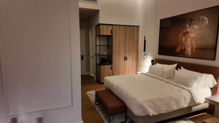 View of king-size hotel bed and wooden wardrobe at Radisson Collection Basilica Budapest